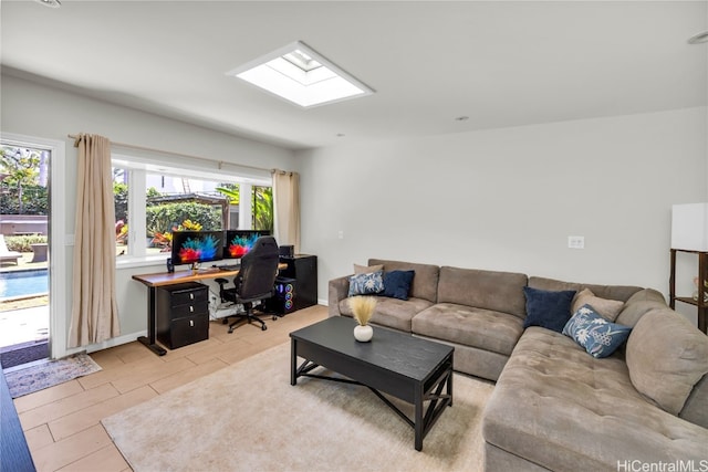 living room with a skylight, light hardwood / wood-style flooring, and a healthy amount of sunlight