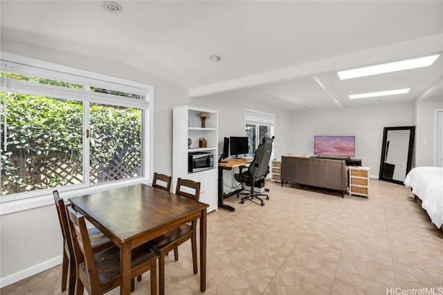 dining space featuring vaulted ceiling with beams