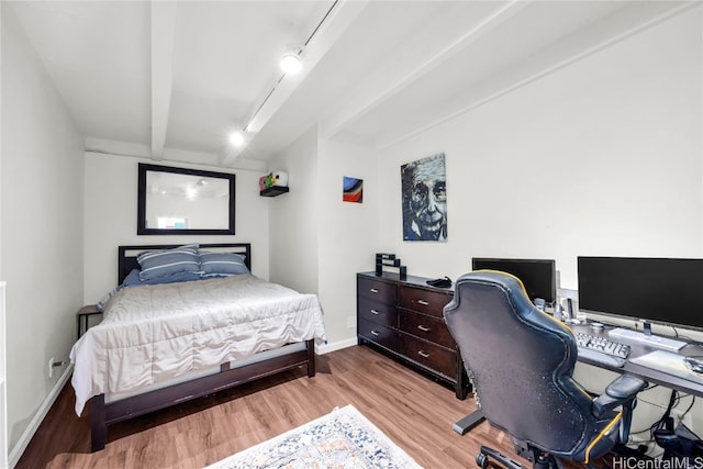 bedroom with beam ceiling, light wood-type flooring, and rail lighting