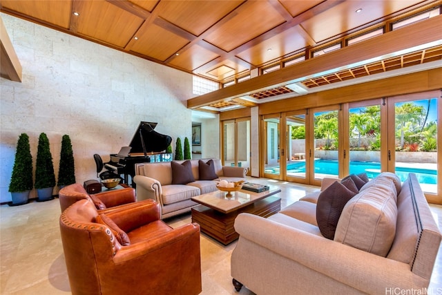 living room with french doors, a towering ceiling, coffered ceiling, and wooden ceiling