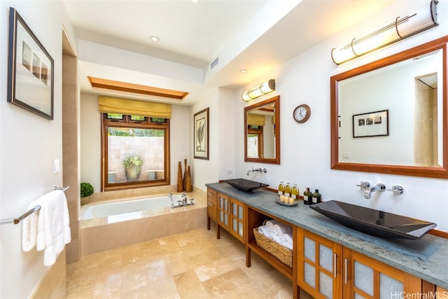 bathroom with vanity and tiled bath