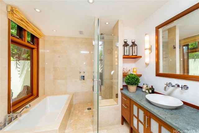 bathroom featuring vanity, tile patterned flooring, and shower with separate bathtub