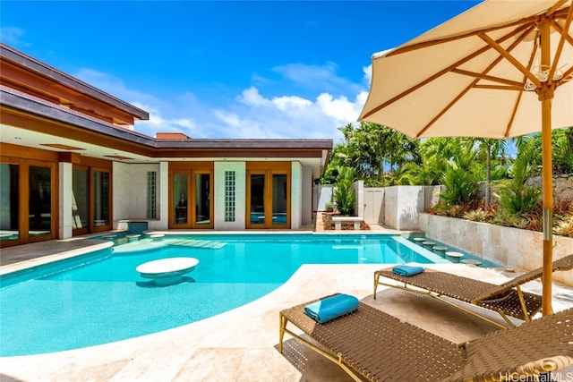 view of swimming pool with french doors and a patio area