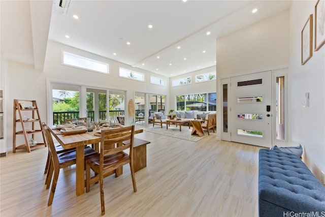 dining room featuring a high ceiling and light hardwood / wood-style flooring