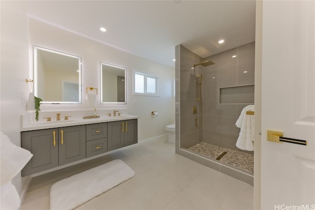 bathroom featuring tiled shower, toilet, tile patterned floors, and vanity