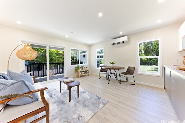 living room featuring an AC wall unit and light hardwood / wood-style flooring