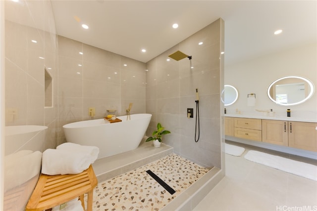 bathroom featuring independent shower and bath, vanity, tile walls, and tile patterned flooring