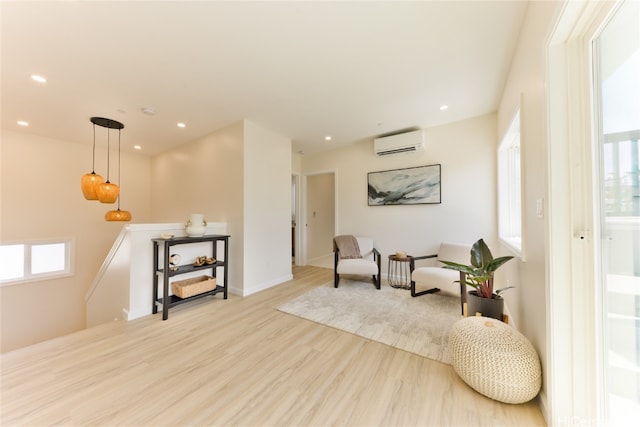 sitting room featuring an AC wall unit and light hardwood / wood-style flooring