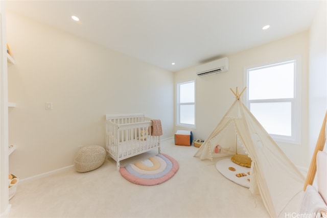 bedroom featuring a wall mounted air conditioner, a crib, and carpet floors