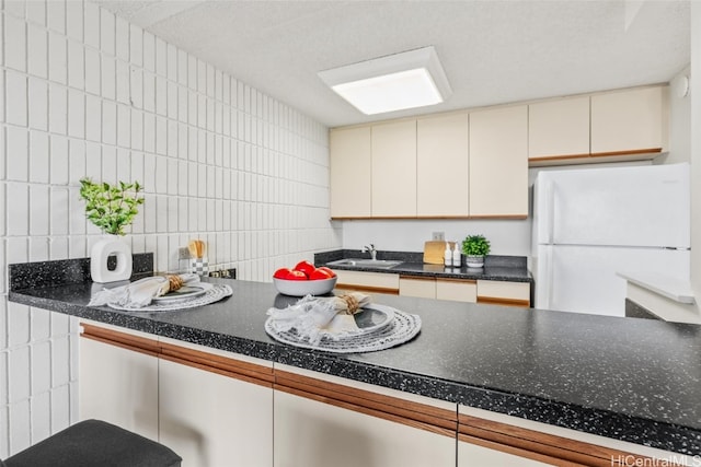 kitchen featuring tasteful backsplash, sink, and white refrigerator