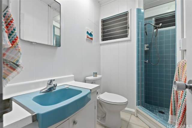 bathroom with tiled shower, vanity, tile patterned floors, and toilet