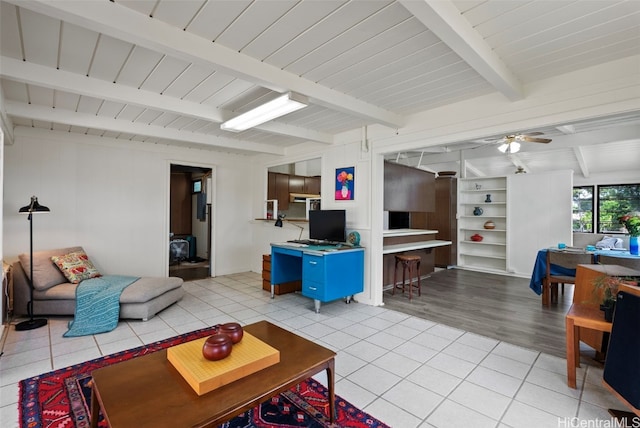 living room featuring beamed ceiling, ceiling fan, and light tile patterned floors