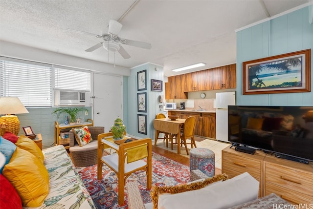 living room featuring ceiling fan, a textured ceiling, cooling unit, and sink