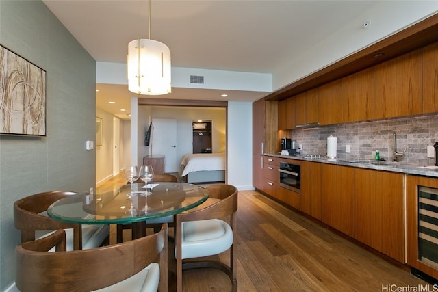 dining area with dark wood-type flooring, sink, and beverage cooler