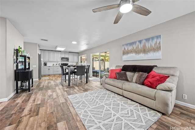 living room with hardwood / wood-style floors and ceiling fan