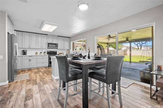 dining space featuring ceiling fan and light hardwood / wood-style floors