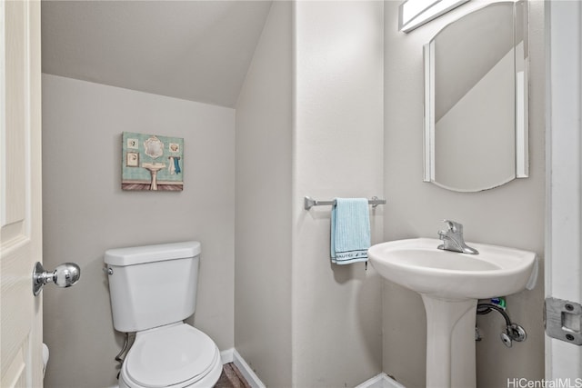 bathroom with toilet and lofted ceiling