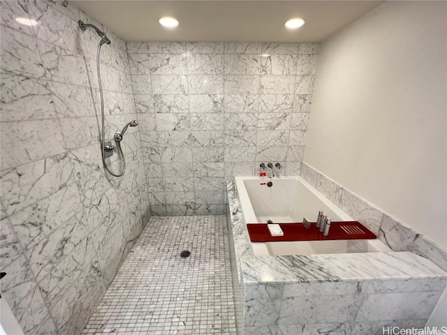 bathroom featuring tile walls and shower with separate bathtub