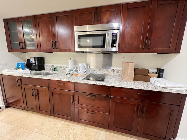223 Saratoga Rd Unit 1108, Honolulu, HI 96815 - kitchen featuring stainless steel microwave, a sink, black electric stovetop, glass insert cabinets, and light stone countertops