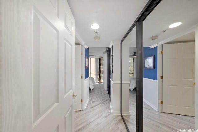 hall featuring light wood-type flooring and crown molding