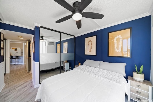 bedroom with wood-type flooring, a textured ceiling, ceiling fan, and crown molding