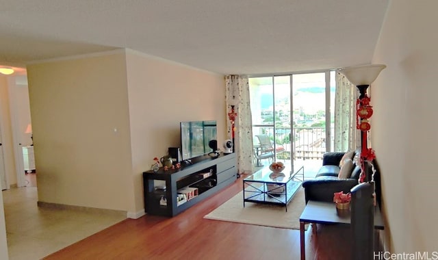 living room featuring hardwood / wood-style flooring, ornamental molding, and floor to ceiling windows