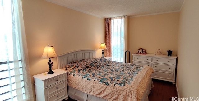 bedroom with crown molding, a textured ceiling, and dark hardwood / wood-style floors