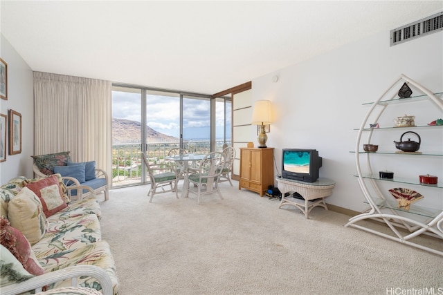 living room featuring a wall of windows and carpet flooring