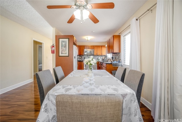 dining area featuring ceiling fan, a textured ceiling, and dark hardwood / wood-style floors