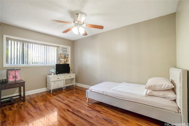 bedroom with dark wood-type flooring, ceiling fan, and a textured ceiling