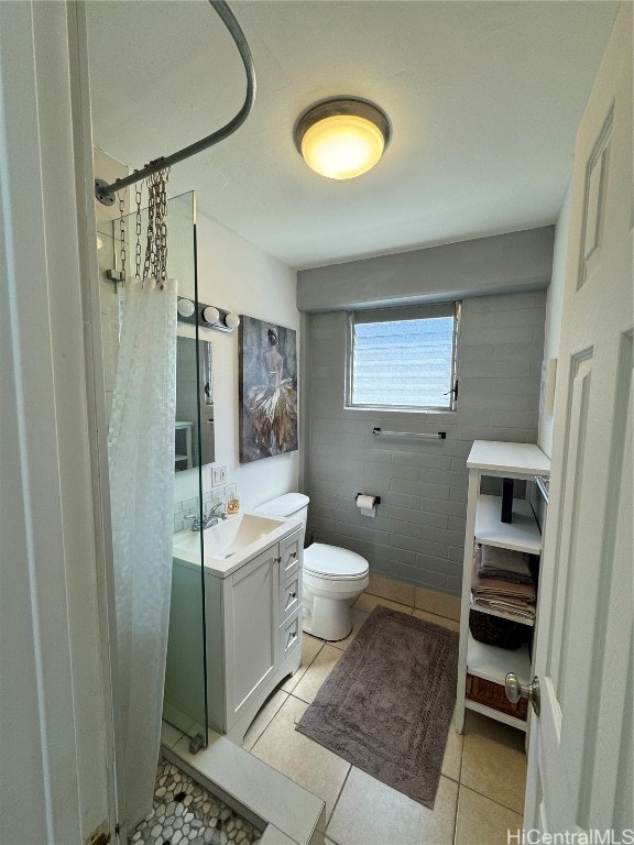 bathroom with vanity, toilet, curtained shower, and tile patterned flooring