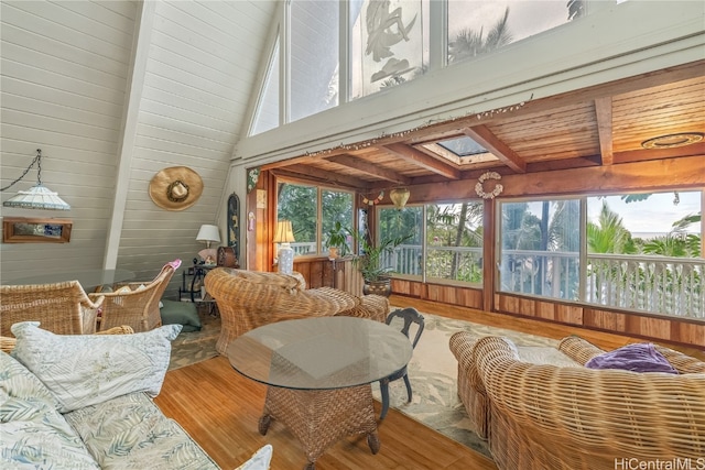 sunroom with lofted ceiling with skylight and wooden ceiling