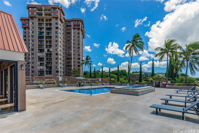 community pool with a community hot tub and a patio area