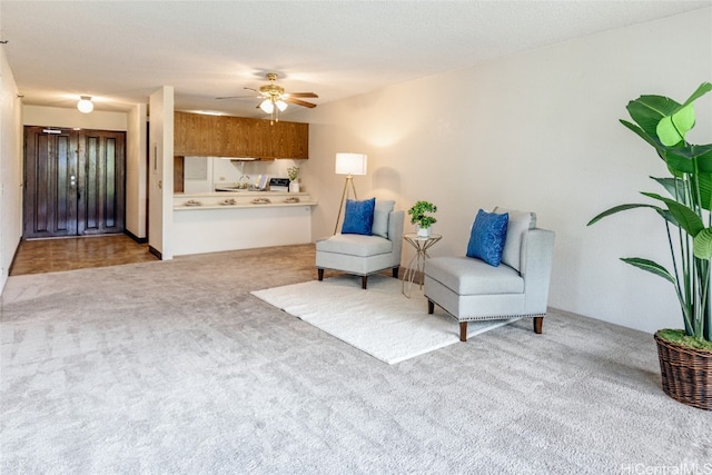 living area with light colored carpet and ceiling fan