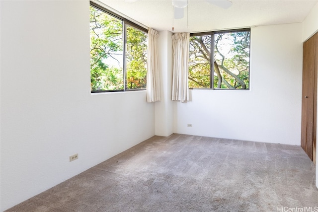 carpeted empty room featuring a ceiling fan