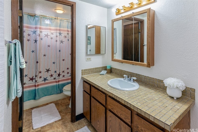 full bath featuring shower / tub combo with curtain, a textured wall, vanity, and toilet