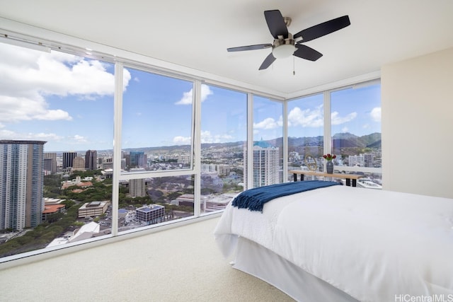 bedroom featuring a wall of windows, multiple windows, and ceiling fan