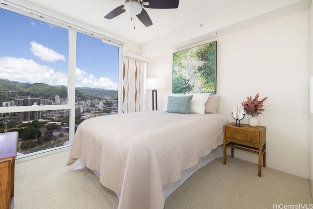 bedroom featuring a mountain view, carpet floors, and ceiling fan