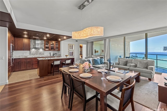 dining area with dark wood-type flooring and a water view