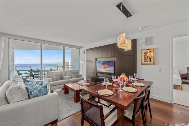 dining area with a water view and dark hardwood / wood-style flooring