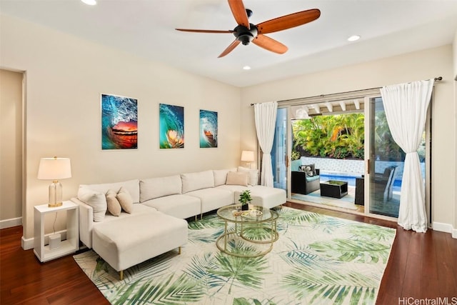 living room featuring ceiling fan and dark wood-type flooring