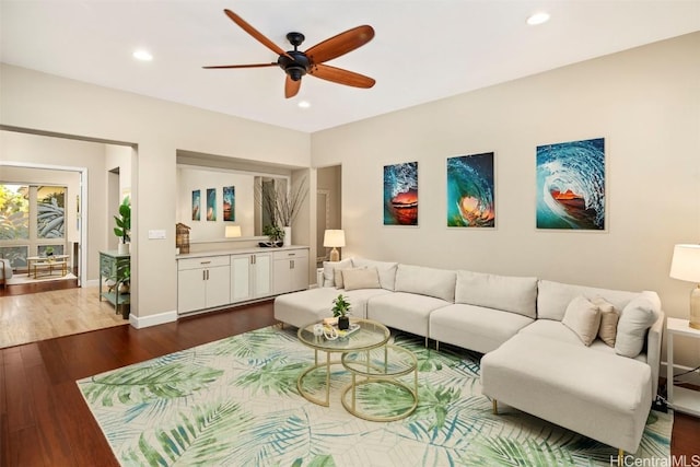 living room featuring ceiling fan and dark hardwood / wood-style flooring