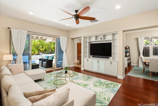 living room with ceiling fan and dark hardwood / wood-style flooring