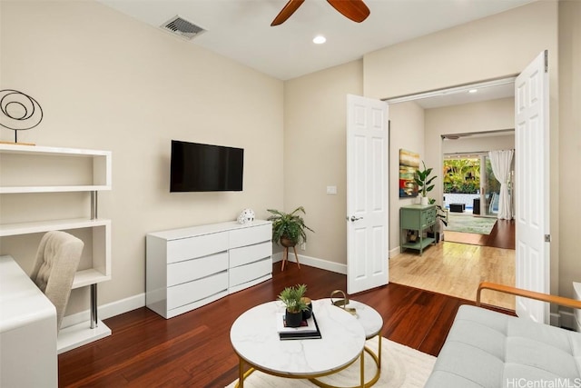 living room featuring ceiling fan and dark hardwood / wood-style flooring