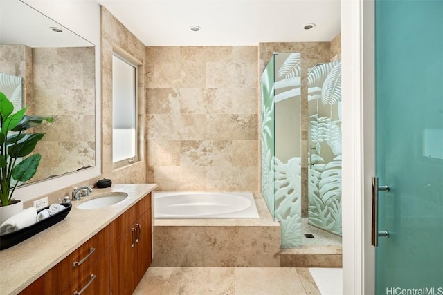 bathroom with vanity, tile walls, and independent shower and bath