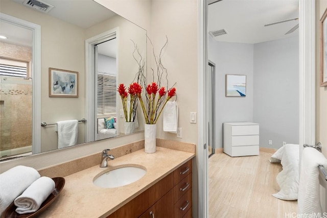 bathroom with ceiling fan, hardwood / wood-style floors, and vanity