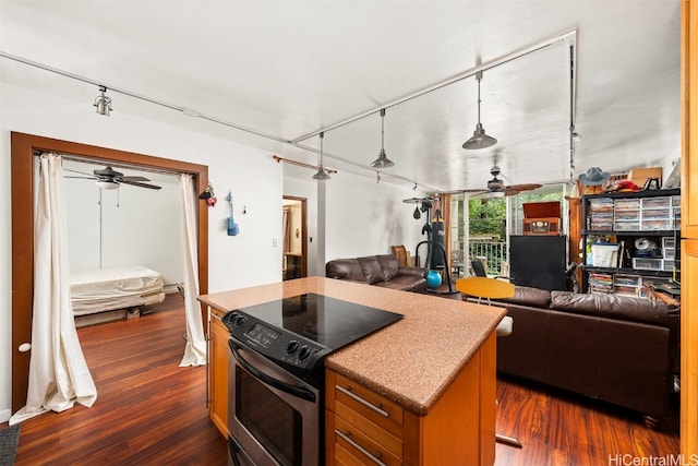 kitchen with a kitchen island, electric range, decorative light fixtures, and dark hardwood / wood-style floors