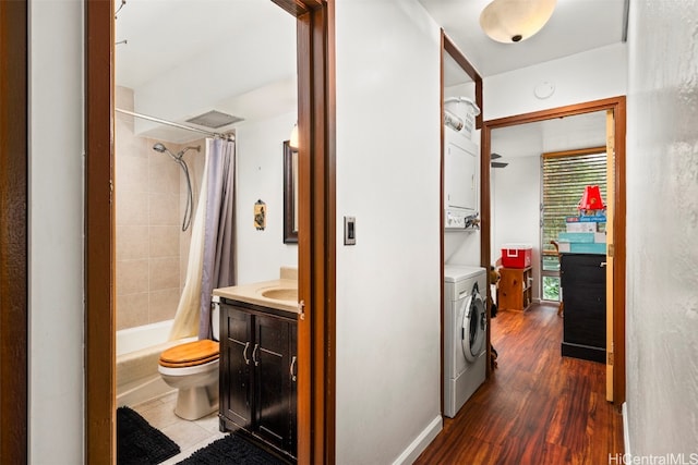 full bathroom with toilet, vanity, hardwood / wood-style flooring, shower / bathtub combination with curtain, and stacked washer and clothes dryer