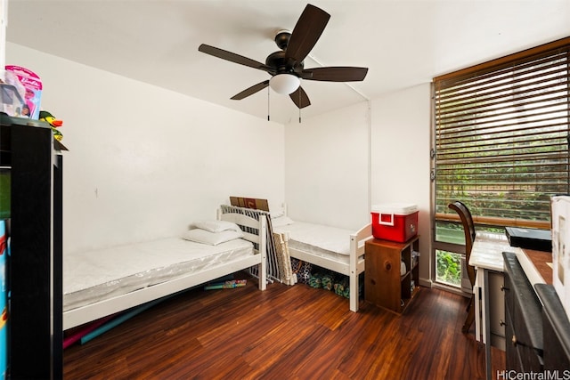 bedroom with ceiling fan, multiple windows, and dark hardwood / wood-style flooring