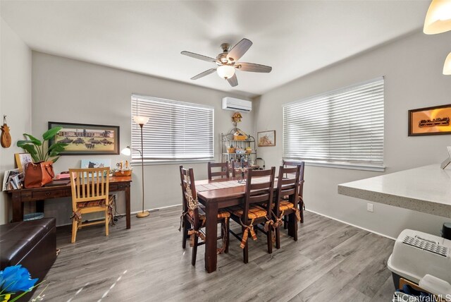 dining space featuring hardwood / wood-style floors, an AC wall unit, and ceiling fan